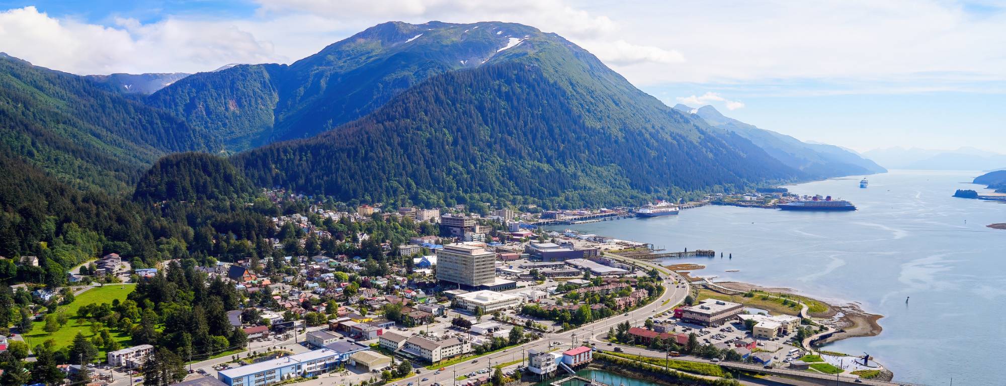 Aerial view of downtown Juneau, Alaska, under Mount Juneau, with cruise ships along Gastineau Channel